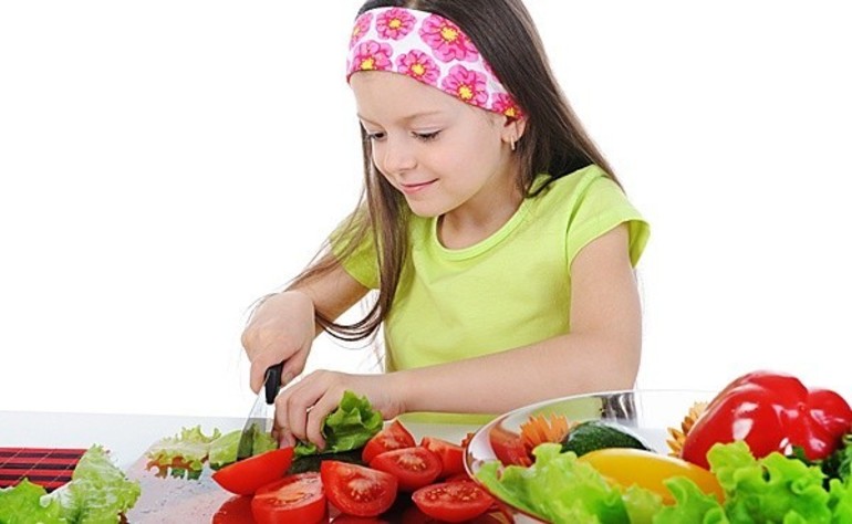 Девочка режет овощи